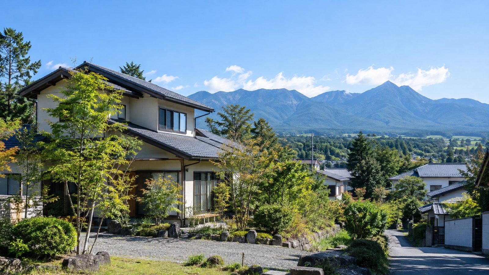 八ヶ岳と青空を背に、庭木の緑に囲まれた明るい戸建て住宅（イメージ）
